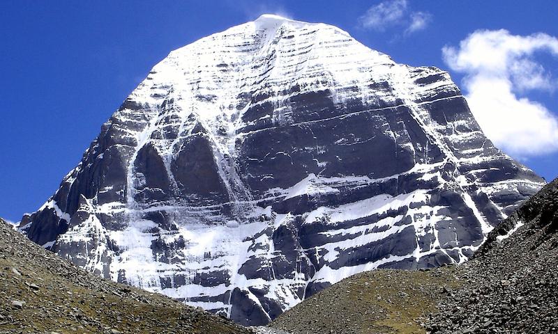 Mount Kailash in Tibet, a large mountain with snow and a blue sky behind it
